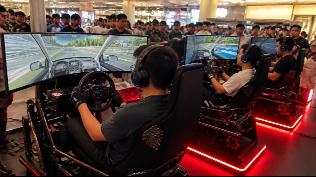 Sim racing rig running Gran Turismo 7 at an AKG Esports event in Kota Kinabalu