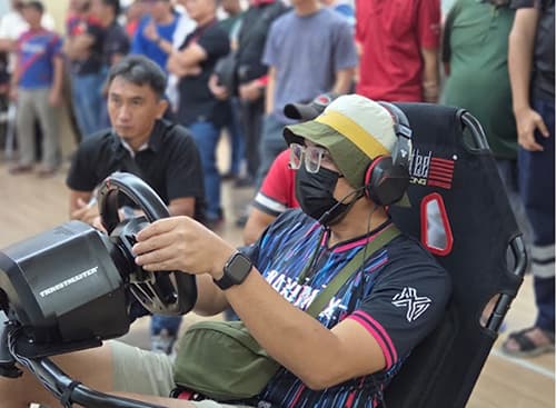 Employee racing on a sim rig while colleagues watch